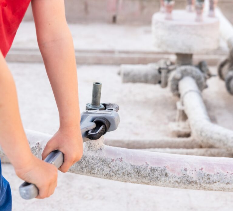 Children using a heavy-duty straight pipe plumbing wrench to repair a pipe.